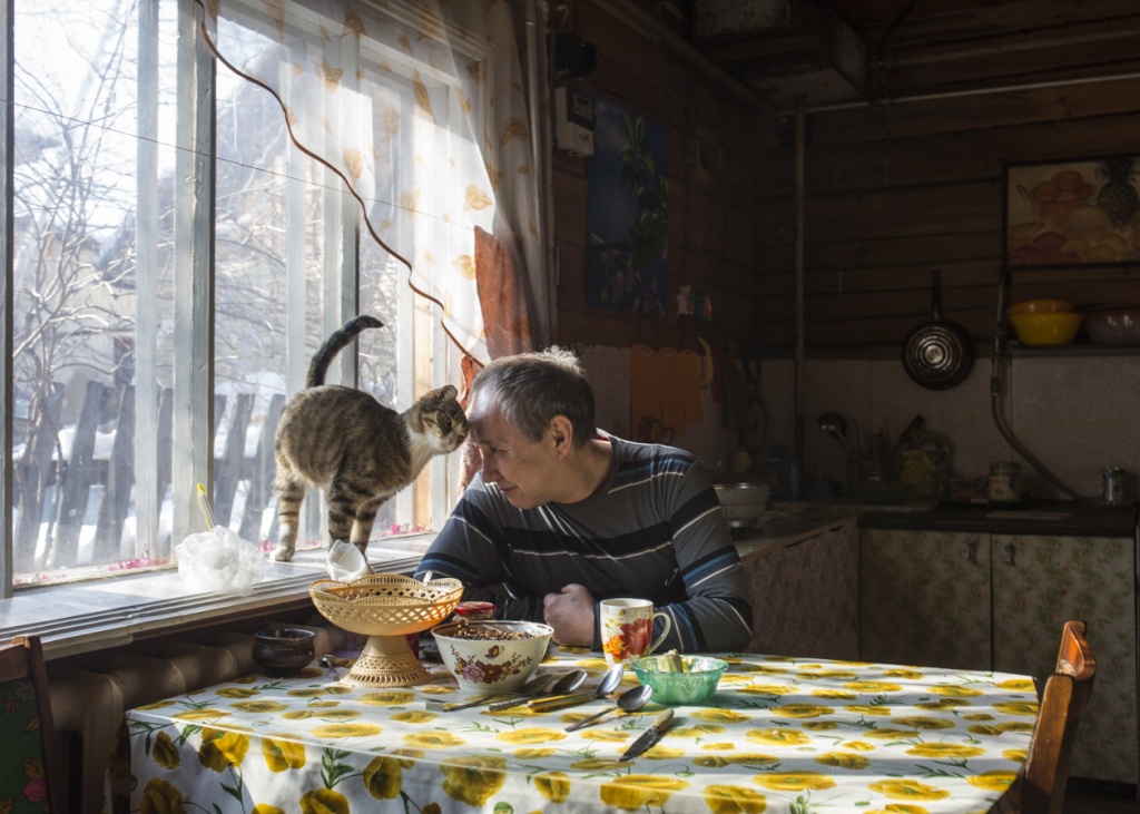 Евгений Андреев, житель села Хатассы в 10 км от Якутска, у себя дома на кухне с котом Котей.