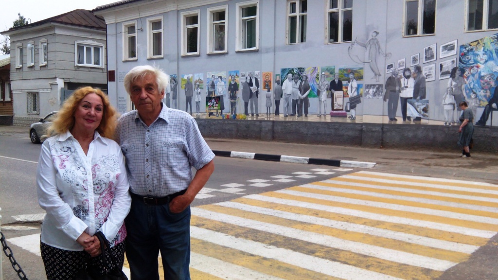 Владимир Овчинников с женой на фоне своей работы «Что есть искусство».
